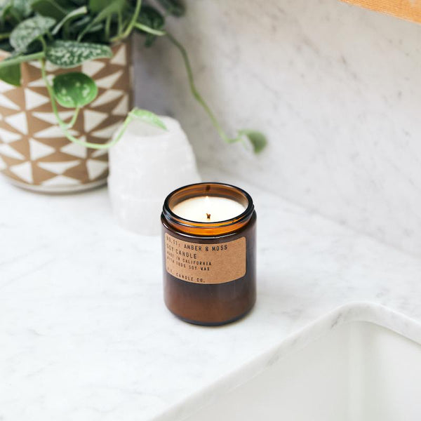 P.F. Candle Co. EU Amber & Moss Standard Candle - Lifestyle - Scent notes of sage, moss, and lavender. Inspired by a weekend in the mountains, sun gleaming through the canopy.