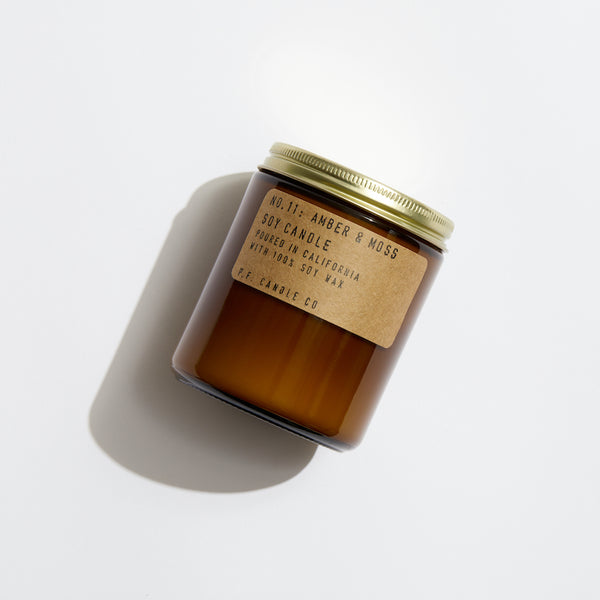 P.F. Candle Co. EU Amber & Moss Standard Candle - Product - Hand-poured into apothecary inspired amber jars with our signature kraft label and a brass lid.