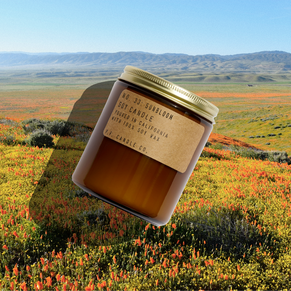 P.F. Candle Co. Sunbloom Standard Candle - Lifestyle - Infinite blankets of kaleidoscopic wildflowers, stopping off the highway to revel in the rainbows, bursting bouquets on full display. Golden-rayed lily, yarrow, and tonka 