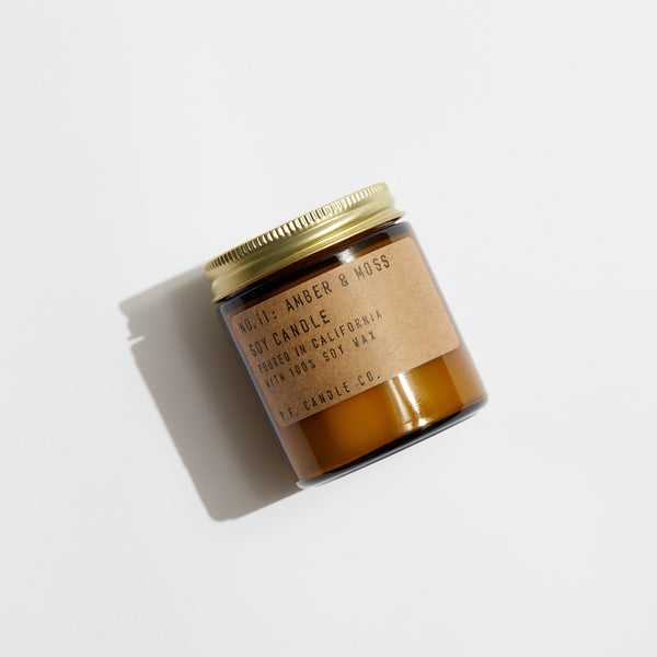 P.F. Candle Co. EU Amber & Moss Mini Candle - Product - Our 3.5 oz Mini Candles are hand-poured into apothecary inspired amber jars with our signature kraft label and a brass lid.