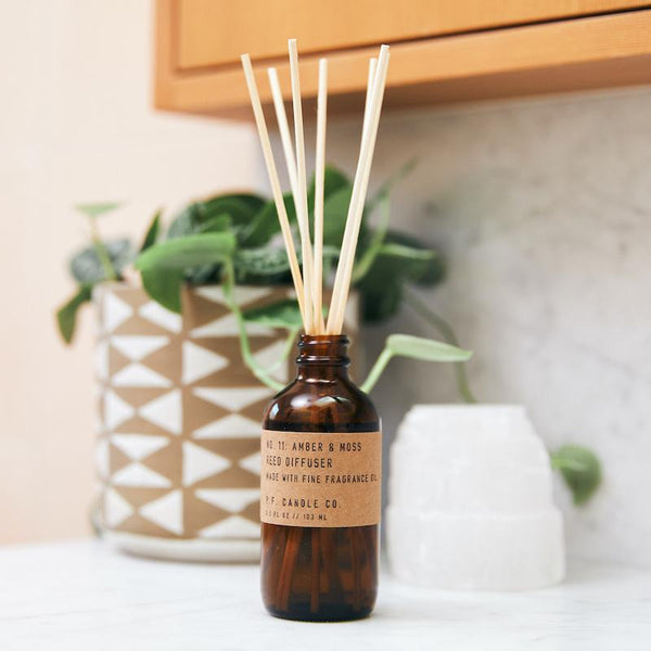 P.F. Candle Co. EU - Amber & Moss Classic 3.5 fl oz Scented Reed Diffuser - Lifestyle - Scent notes of sage, moss, and lavender. Inspired by a weekend in the mountains, sun gleaming through the canopy.