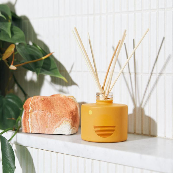 P.F. Candle Co. EU Golden Hour Sunset Reed Diffuser - Lifestyle - 5pm. Rustling grasses, baked earth, sun rays split between trees. Mellow, dry, tranquil. Bergamot, hay, and golden poppy.