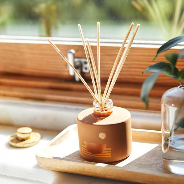 P.F. Candle Co. EU Swell Sunset Reed Diffuser - Lifestyle - 12pm. Salty skin, steady tides, endless afternoons in the hot summer sun. Vibrant, juicy, aquatic. Black currant, tuberose, and sea moss.